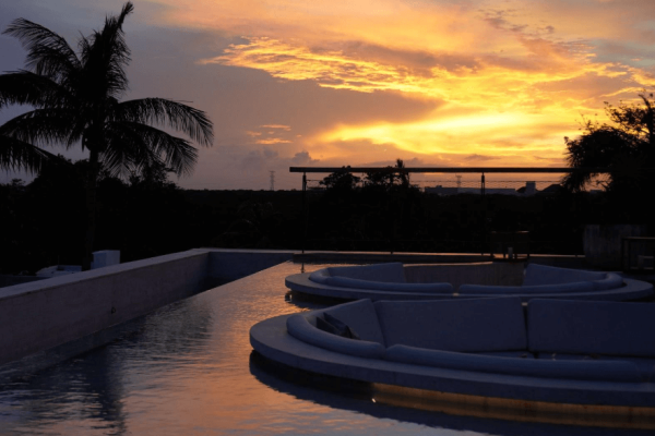 rooftop pool with sunset mirroring off water